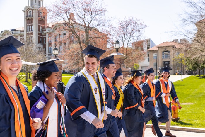 Group of graduates from the Class of 2022 walk together on campus down the Einhorn Family Walk