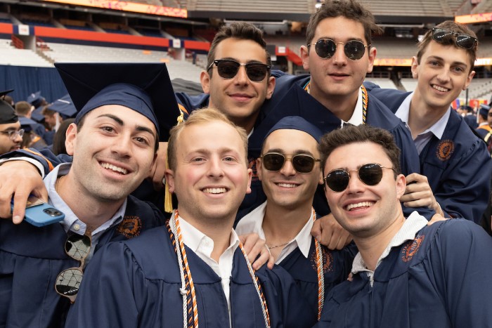 Group of graduates smile together after the Commencement 2023 ceremony